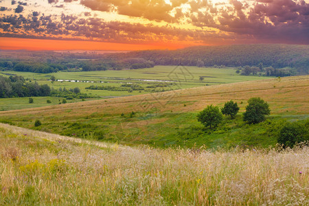 风景日落天空绿草夏天自然草甸山全景领域地平线图片