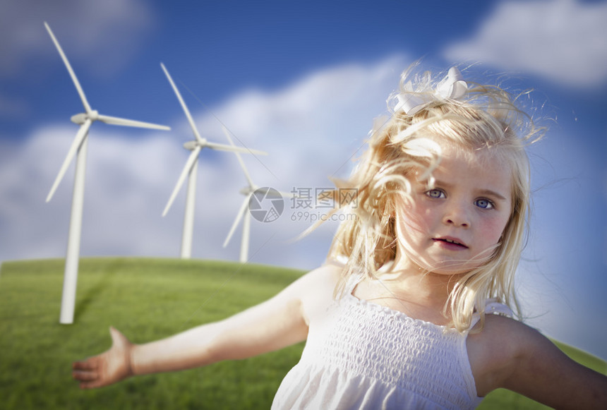 美丽的年轻女孩在风力涡轮机和草地附近玩耍图片