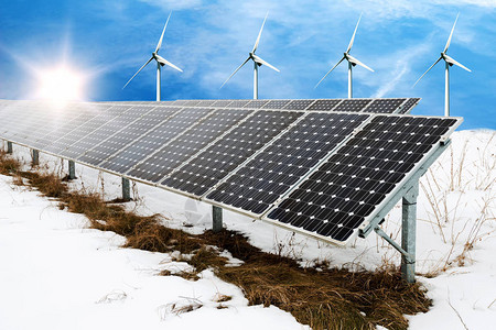 冬季太阳能电池板和风涡轮宾与雪可持续资源概图片