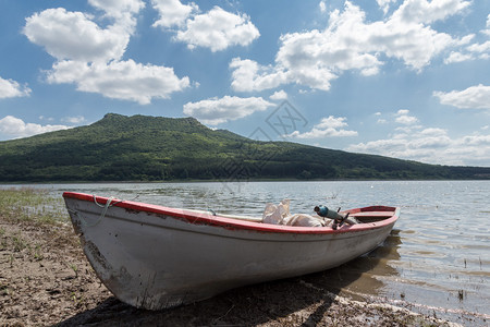 多云的湖面上孤独的渔船图片