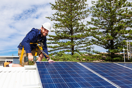 太阳能电池板技术员在屋顶上安装图片