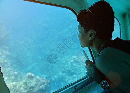 女人坐在窗边的玻璃底船上图片