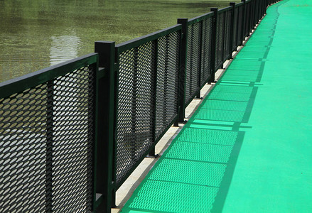 湖边有金属栅栏的绿色人行道图片