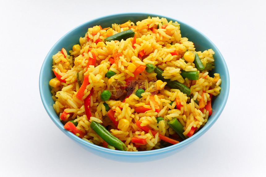 白色背景的蓝色碗里放着蔬菜的米饭图片