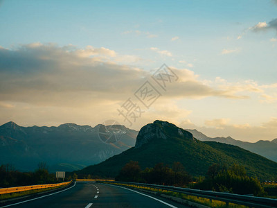 穿过山上的道路日落图片