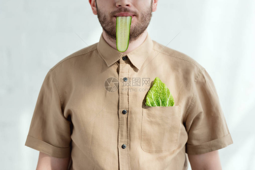 口中吃黄瓜切片和口袋中吃菜卷心菜叶素食图片