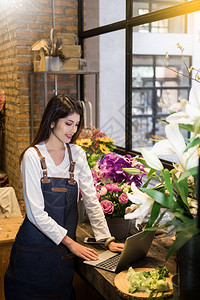 寻找花女的笔记本电脑在花店柜台订了菜图片