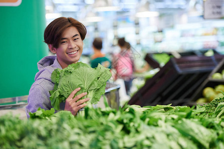 在超市购买绿色蔬菜的男人图片