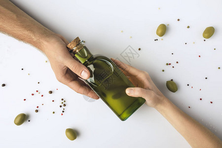 男人和女人将橄榄油瓶放在白纸上孤立的手图片