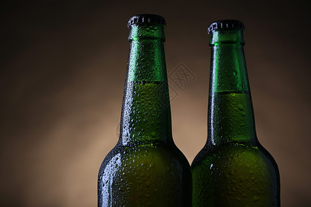 两瓶绿色玻璃啤酒深暗的灯图片