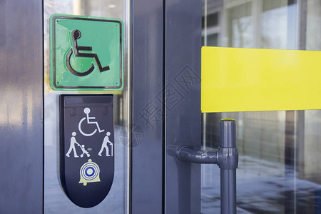 要求使用玻璃前门的建筑物和标志有残疾人坐在轮椅上和手持拐杖的图片