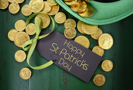 圣帕特里克节快乐小妖精帽子和金巧克力硬币在古老风格的图片