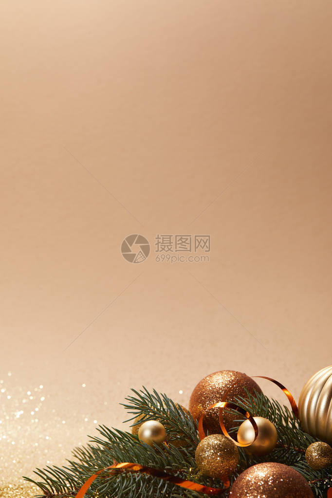 松树枝上闪发亮的圣诞球在蜜滩上隔图片