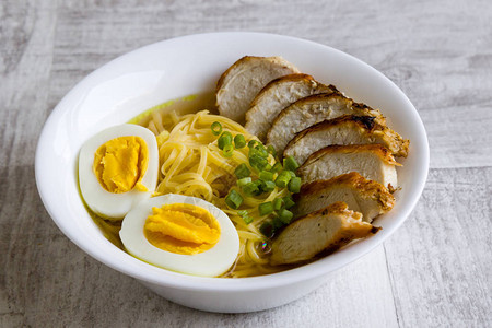 日式拉面汤配鸡肉和白碗煮鸡蛋图片