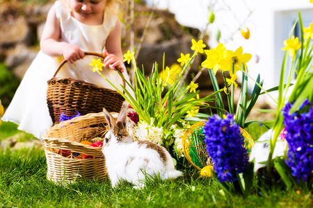 春天在草地上寻找复活节彩蛋的小女孩图片