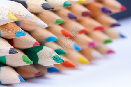 在白色上隔离的一堆彩虹铅笔的特写图片