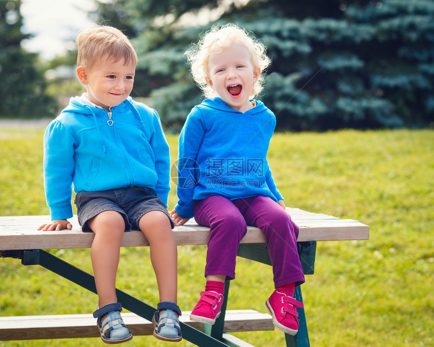 白人可爱的男孩和女孩朋友的肖像笑着在夏日外面公园里聊天拥抱图片