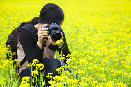 年轻女摄影师拍摄自然照片的年图片