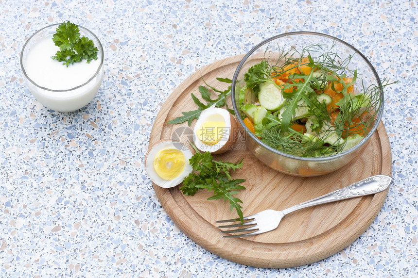 木板上的玻璃碗里放着新鲜蔬菜和香草的沙拉煮鸡图片