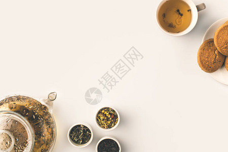 茶壶中新鲜有机草药茶碗中的干草药和白饼图片