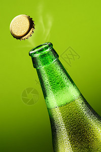 绿色背景上开盖的啤酒瓶图片
