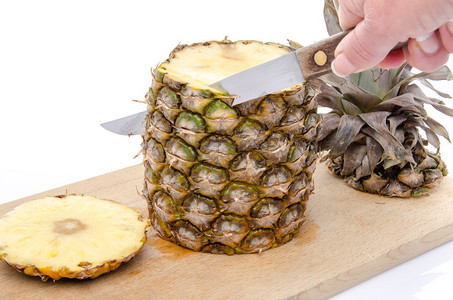 手在木板上剥菠萝用白色隔开背景图片