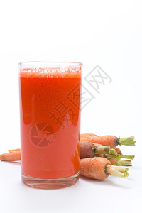 一杯胡萝卜汁和新鲜胡萝卜用白色隔开图片