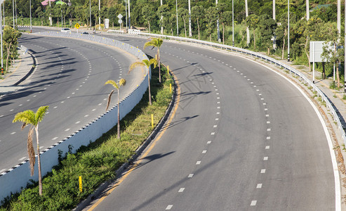 道路弯曲空荡的道路两边有树图片