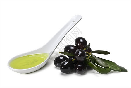 黑色橄榄和一汤匙橄榄油在白色图片