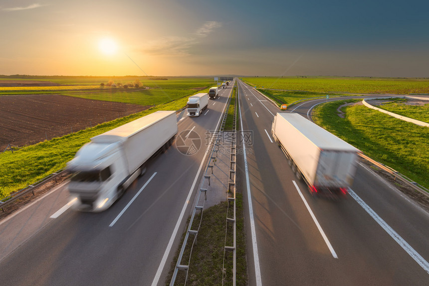 许多送货卡车穿过农田在美丽的日落高速公路上的快速模糊运动图像塞尔维亚贝尔格莱德附近高速公路图片
