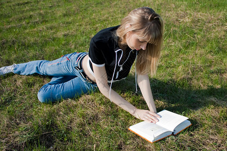 女孩看书躺在绿草地上图片