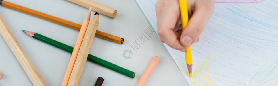 孩子用黄色铅笔在纸上画的全景照片背景图片