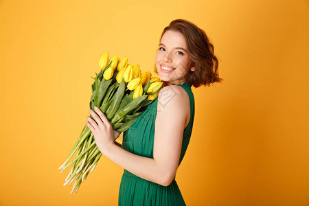 幸福女人的一面黄色的郁金香花束在橙色与图片