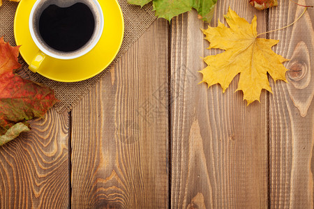 秋叶和咖啡杯在木本背景上图片