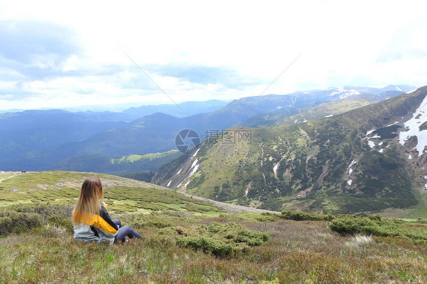 金发女游客坐在阿尔卑斯山上观光山区的旅游和暑假概念图片