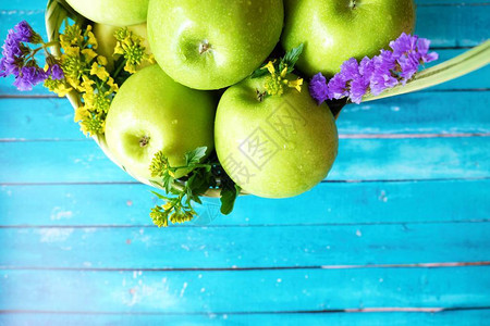 篮子里有鲜花的新鲜青苹果图片
