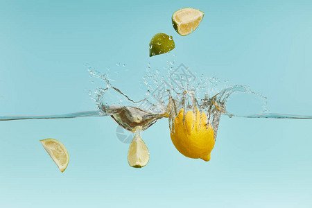 成熟的柠檬和石灰片落入水中图片