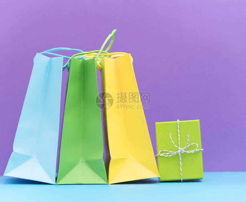 紫色背景上的彩色购物袋和礼品盒图片