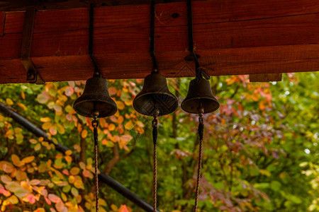 棕色木梁上挂着三个小铃铛图片