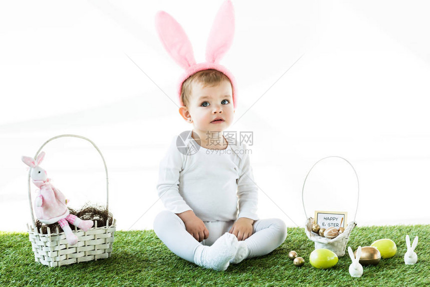 戴着耳朵头带的可爱婴儿坐在草篮附近图片