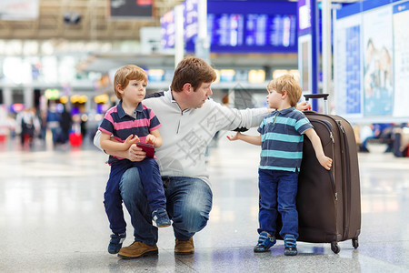 疲惫的父亲和两个小男孩在机场一起旅行图片