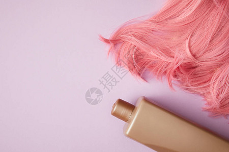 亮粉色假发和紫色空白容器的顶视图背景图片