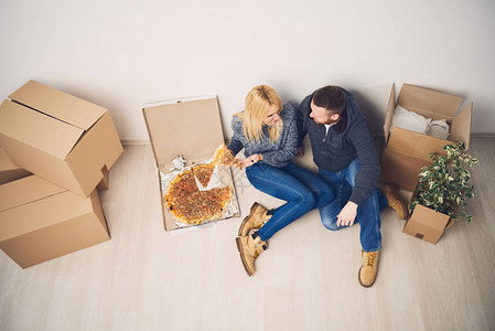夫妇在新公寓里吃披萨图片