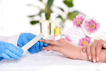 在美容院的餐桌上给女人做指甲涂指甲修指甲时用乳胶图片