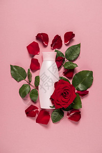 玫瑰花瓣上的润肤露瓶和粉红色上的叶子图片