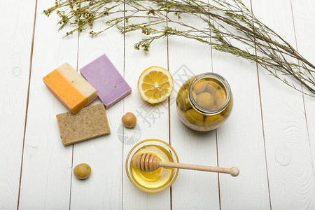 木制桌上有柠檬橄榄和蜂蜜的手工图片