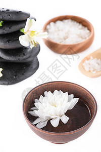 锌石海盐带水的木碗和白上孤立的花图片