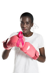 戴着拳击手套的年轻非洲裔美国女拿着粉红丝带图片