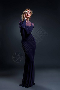 金发美女穿着深紫色的雪佛兰蕾丝裙和饰品工作室在暗底背景拍背景图片