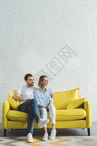 年轻男人在现代房间的黄色沙发图片